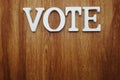 Wooden letters with word vote alphabet on wooden backgrou