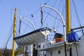 Wooden lifeboat is suspended from stern ship.