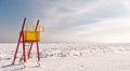 Wooden lifeguard tower stands near the black sea covered in snow in winter Royalty Free Stock Photo