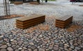 paving gray brown beige color of natural stone boulders of irregular shapes and colors. Benches around a square and rectangular Royalty Free Stock Photo