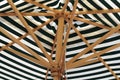 Wooden linkage in a green striped umbrella Royalty Free Stock Photo