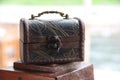 A wooden little chest of brown color, an ancient lock and a metal handle. Service concept small box for tips.