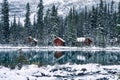 Wooden lodge in pine forest with heavy snow reflection on Lake O'hara at Yoho national park Royalty Free Stock Photo