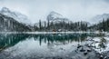 Wooden lodge in pine forest with heavy snow reflection on Lake O'hara at Yoho national park Royalty Free Stock Photo