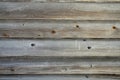 A wooden wall made of gray-brown processed logs as a background close-up Royalty Free Stock Photo