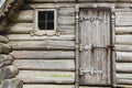 Wooden logs of the wall, the door and window of rural house background. Royalty Free Stock Photo