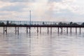 Wooden long bridge over a sea plait, river at sunset in perpektive, against a background of reeds, landscape Royalty Free Stock Photo