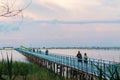 Wooden long bridge over a sea plait, river at sunset in perpektive, against a background of reeds, landscape Royalty Free Stock Photo