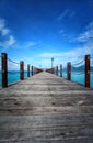 Wooden long jetty with blue sky Royalty Free Stock Photo
