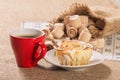 Board game lotto on sackcloth. Wooden lotto barrels in bag and game cards with cup of coffee and homemade cookie on plate Royalty Free Stock Photo