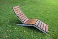 Wooden lounger on a green lawn in the park Royalty Free Stock Photo