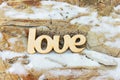 Wooden love sign on stone texture with snow Royalty Free Stock Photo