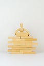 Wooden man builds wall of wooden blocks. concept of creation, construction, business development