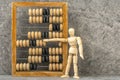 Wooden man counting with old wooden abacus Royalty Free Stock Photo