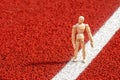 Wooden man doing exercises on running track