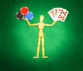 Wooden man with hands up to hold chips and cards for playing poker Royalty Free Stock Photo