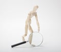Wooden man with magnifying glass Royalty Free Stock Photo