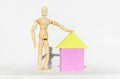 Wooden man next to toy house on white background. concept, mortgage, buying house, security, safety