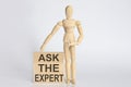Wooden man shows with a hand text Ask The Expert concept on the wooden block Royalty Free Stock Photo