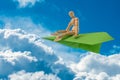 Wooden man sitting on the paper plane and flying over clouds Royalty Free Stock Photo