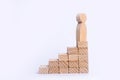 A wooden man stands at the top of a social or career ladder. Concept of business success. Stairs of people. Use other workers. Royalty Free Stock Photo