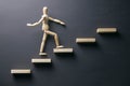 Wooden man walk up the career stairs. Ladder made with wooden bricks. Mannequin on top of development. Concept of personal Royalty Free Stock Photo