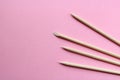Wooden manicure sticks on a pink background