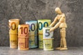 Wooden mannequin and accurately rolled hundred, fifty, twenty, ten and five paper euro banknotes