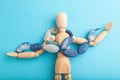 Wooden mannequin with blue agate beads on blue pastel background. copy space Royalty Free Stock Photo