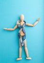 Wooden mannequin with blue agate beads on blue pastel background. copy space Royalty Free Stock Photo