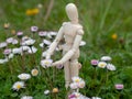 Wooden mannequin between flowers on springtime Ecology and garden concept Royalty Free Stock Photo