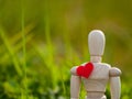 Wooden mannequin with a red heart on his chest. Concept of romanticism and love Royalty Free Stock Photo