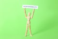 Wooden mannequin holding card with word Responsibility on light green background