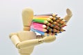 Wooden mannequin loaded with colored pencils