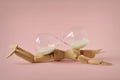 Wooden mannequin lying under hourglass on pink background - Concept of stopping time, health and aging