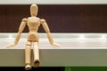 Wooden mannequin or man figurine sitting on white Royalty Free Stock Photo