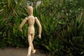 Wooden mannequin in the midst of aloe vera plants. Mediterranean garden with thorny leaves of succulents and model