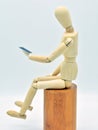 Wooden mannequin with a mobile in hand Royalty Free Stock Photo