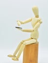 Wooden mannequin with a mobile in hand