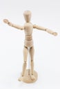 A wooden mannequin with open arms.