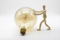 Wooden mannequin pushing a electric light bulb Royalty Free Stock Photo