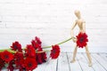 Wooden mannequin with red gerbera flower Royalty Free Stock Photo