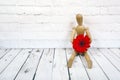 Wooden mannequin with red gerbera flower Royalty Free Stock Photo