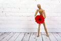 Wooden mannequin with red gerbera flower Royalty Free Stock Photo