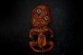 Wooden Maori Hei Tiki hand carved with paua shell eyes. New Zealand taonga. Royalty Free Stock Photo