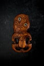 Wooden Maori Hei Tiki hand carved with paua shell eyes. New Zealand taonga. Royalty Free Stock Photo