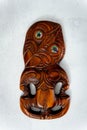 Wooden Maori Hei Tiki hand carved with paua shell eyes. New Zealand taonga. White background. Royalty Free Stock Photo