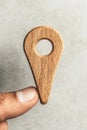 Wooden Map Pointer Held by Finger Against Gray Surface Displaying Cybersecurity Awareness Royalty Free Stock Photo