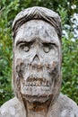 Wooden mask on tree trunk. Closeup view