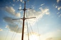 The wooden mast of an old ship on the background of blue sky.Going out to sea and adventures Royalty Free Stock Photo